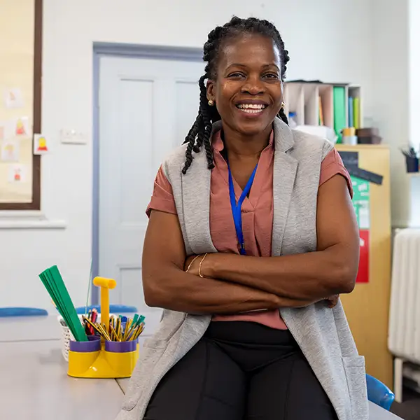 Teacher sat on a desk